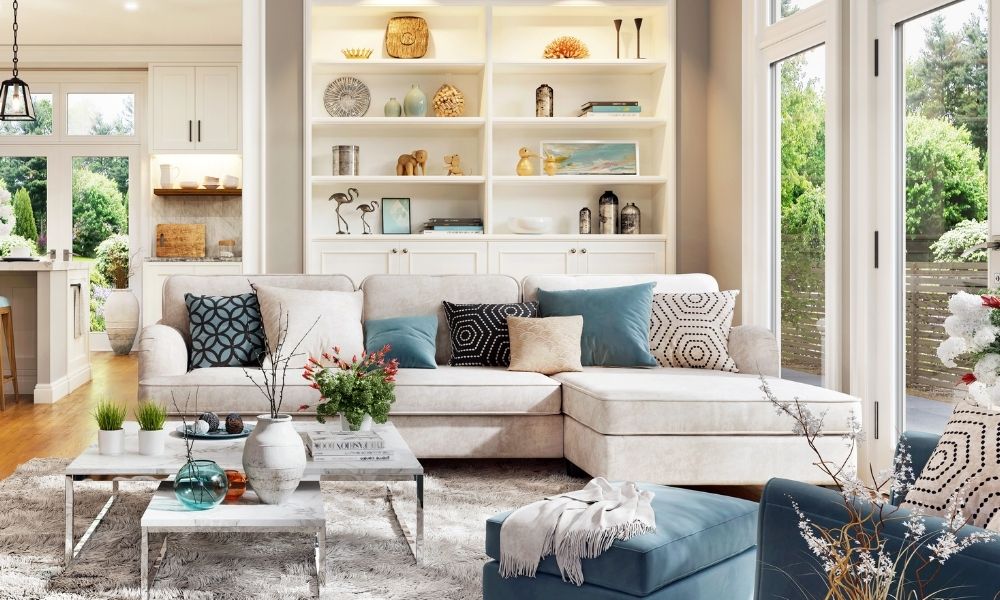 A bright room with sofa with many cushions and two tea tables