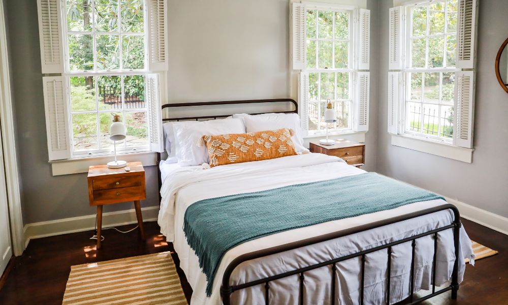 In the bedroom, a orange pillow and green blanket on the bed