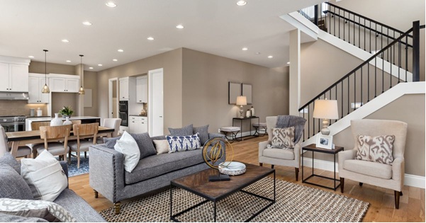 Two young ladies talking one holding a book another with box in a collge dorm